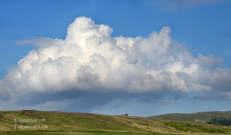 Un núvol corona una típica granja islandesa